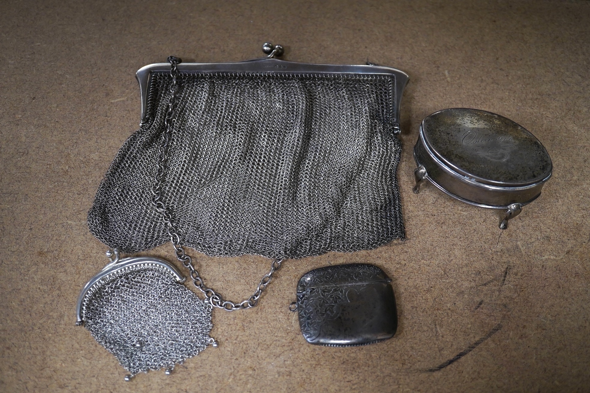 A George V silver trinket box, 68mm, a silver vesta case and two silver mesh evening bags. Condition - poor to fair